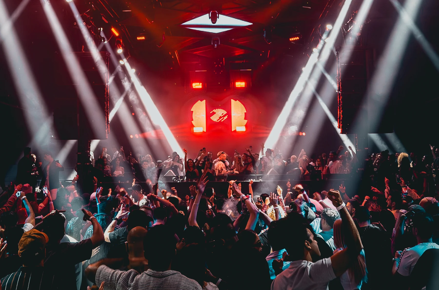 Mia Mendi performing at CODE DXB, surrounded by the crowd and red and white stage lights